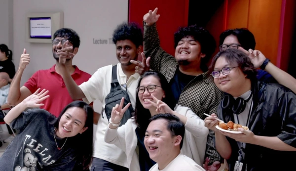 A group of 3dsense students posing together, smiling and making playful gestures in a vibrant outdoor space.