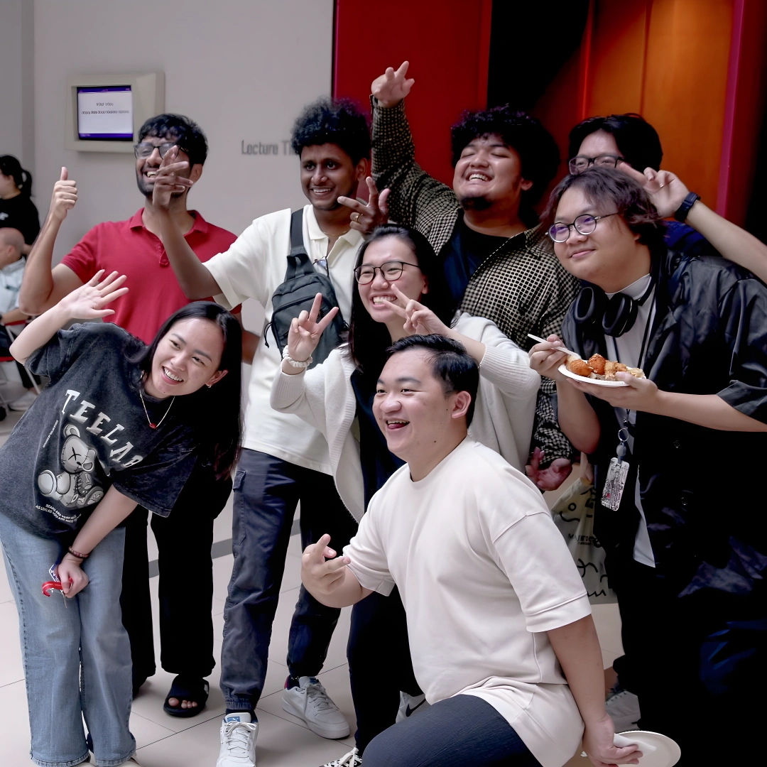 A group of 3dsense students posing together, smiling and making playful gestures in a vibrant outdoor space.
