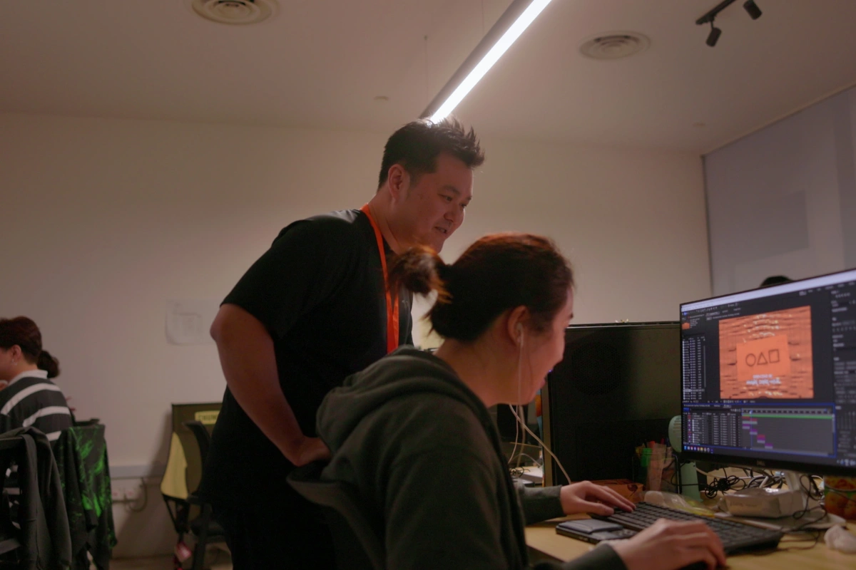 A 3dsense Media School lecturer providing one-to-one guidance to a student during a mentoring session in class.
