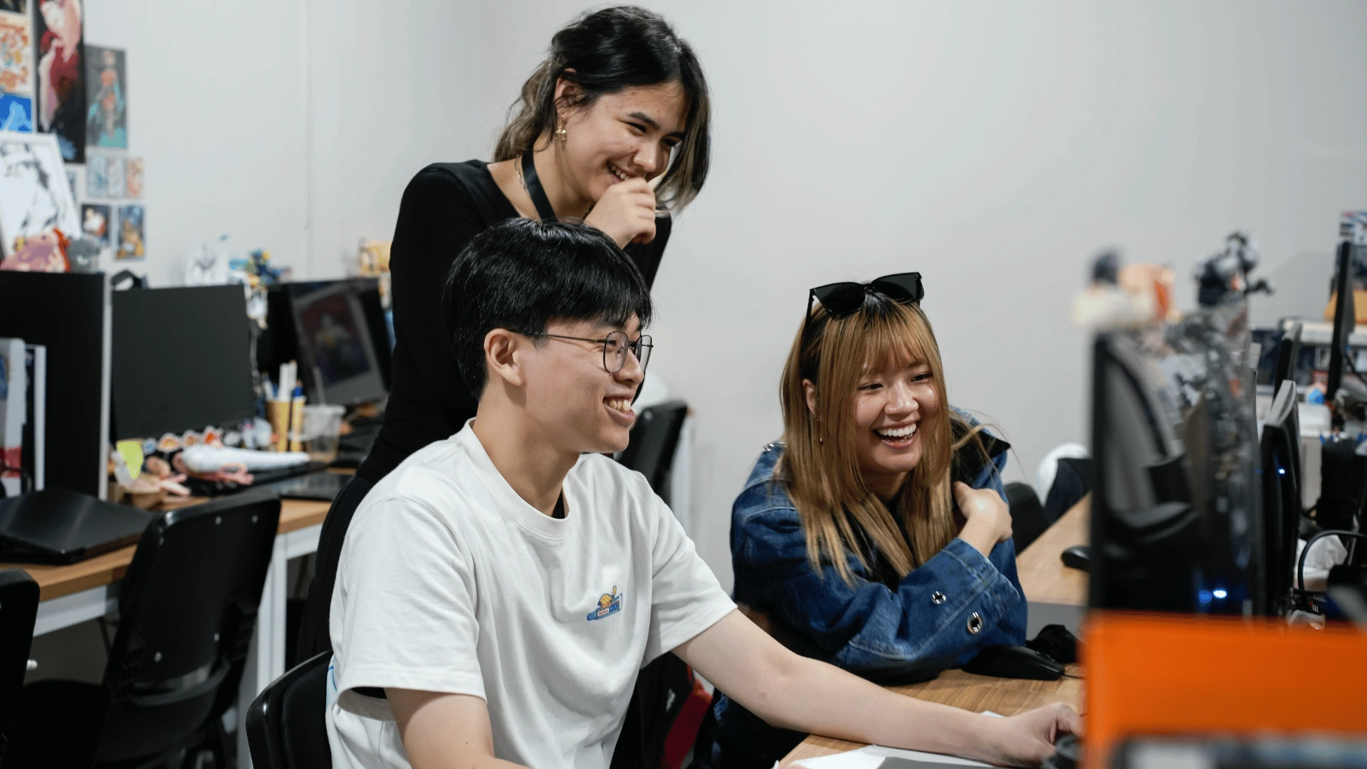 Students discussing creative projects at their workstations